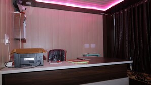 A room with a wooden desk, a printer, a red book, and a black bag.