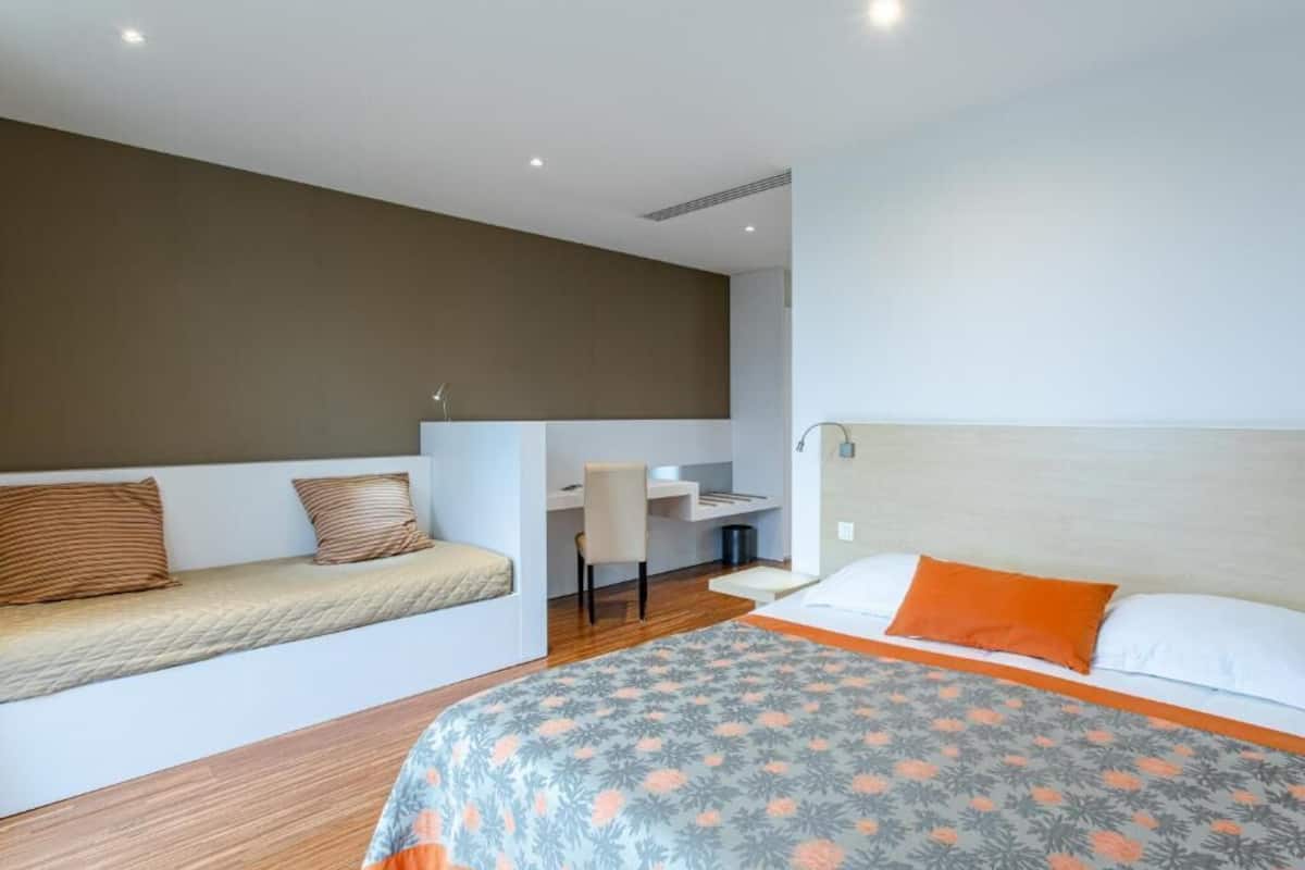 Une chambre à coucher comprenant un lit, un bureau et un coin salon.