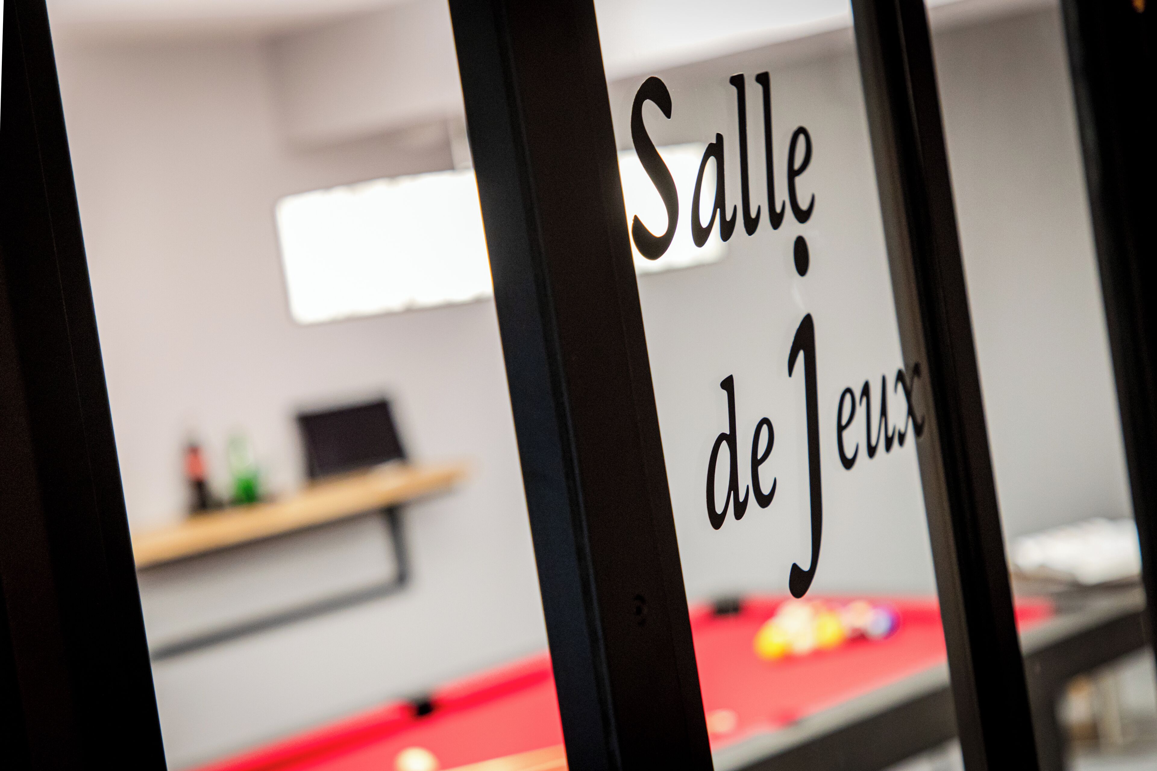 Un cartel con el texto 'Salle de Jeu' que indica una zona de juegos.