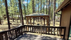 A wooden deck with a gazebo in a forested area. - Modern and Cozy Cabin w Game Room,  Fireplace and all the amenities in PineTop (Pinetop Country Club)