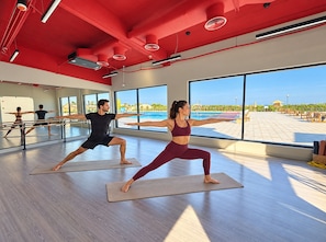 A yoga studio with large windows, a pool view, and a modern design.