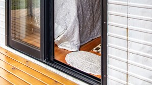Quarto com cama, janela e vista para o exterior.