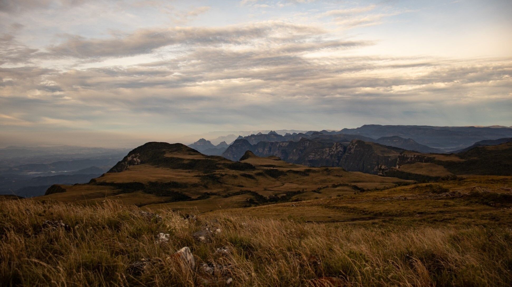 A mountainous landscape with rolling hills and distant peaks.