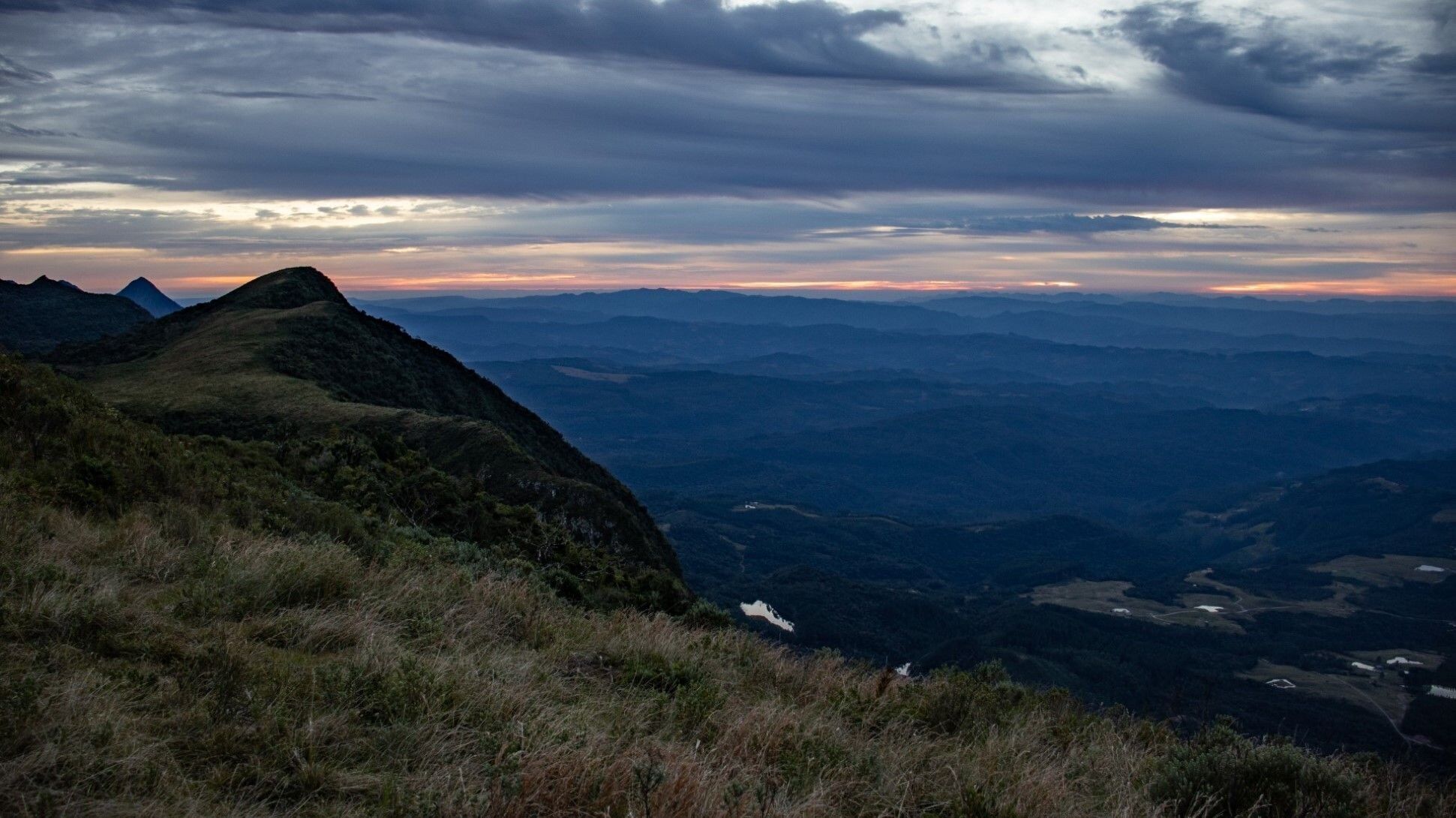 Un paysage montagneux avec une vallée et un sommet lointain.