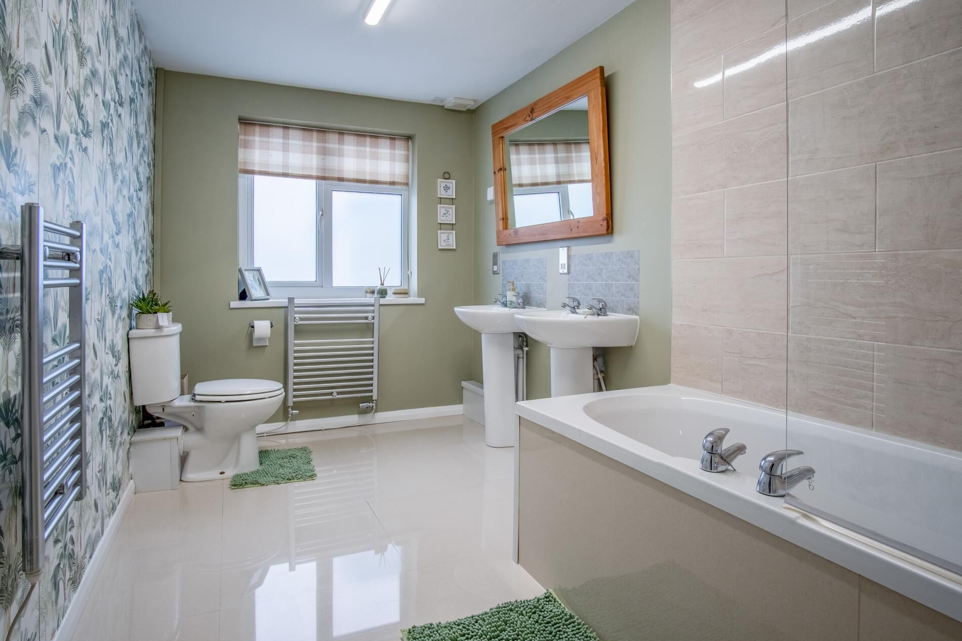 A modern bathroom with a toilet, bidet, sink, and bathtub.
