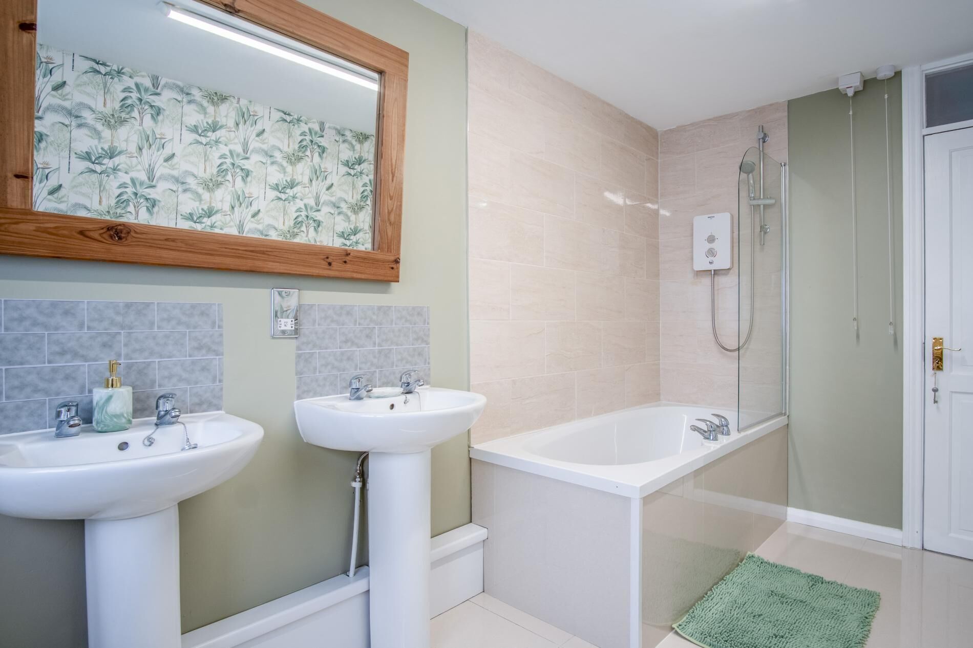 A bathroom with two sinks, a bathtub, and a shower.