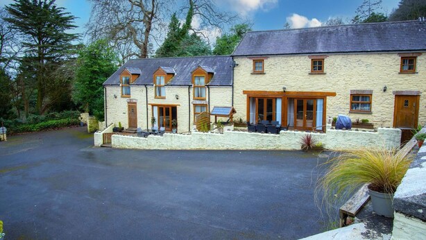 A stone building with a large driveway and outdoor seating area.