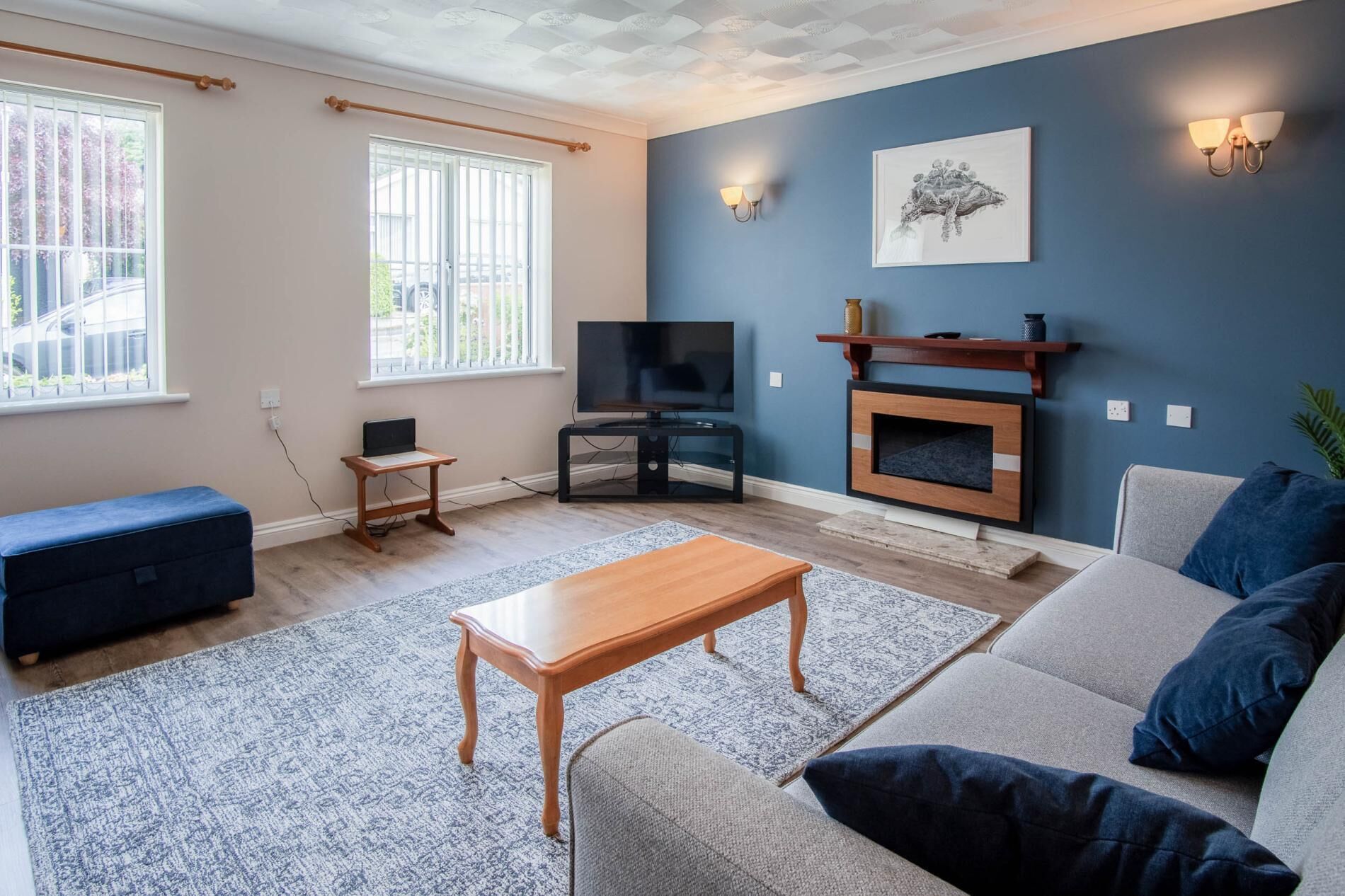 A living room with a sofa, a coffee table, a TV, and a fireplace.