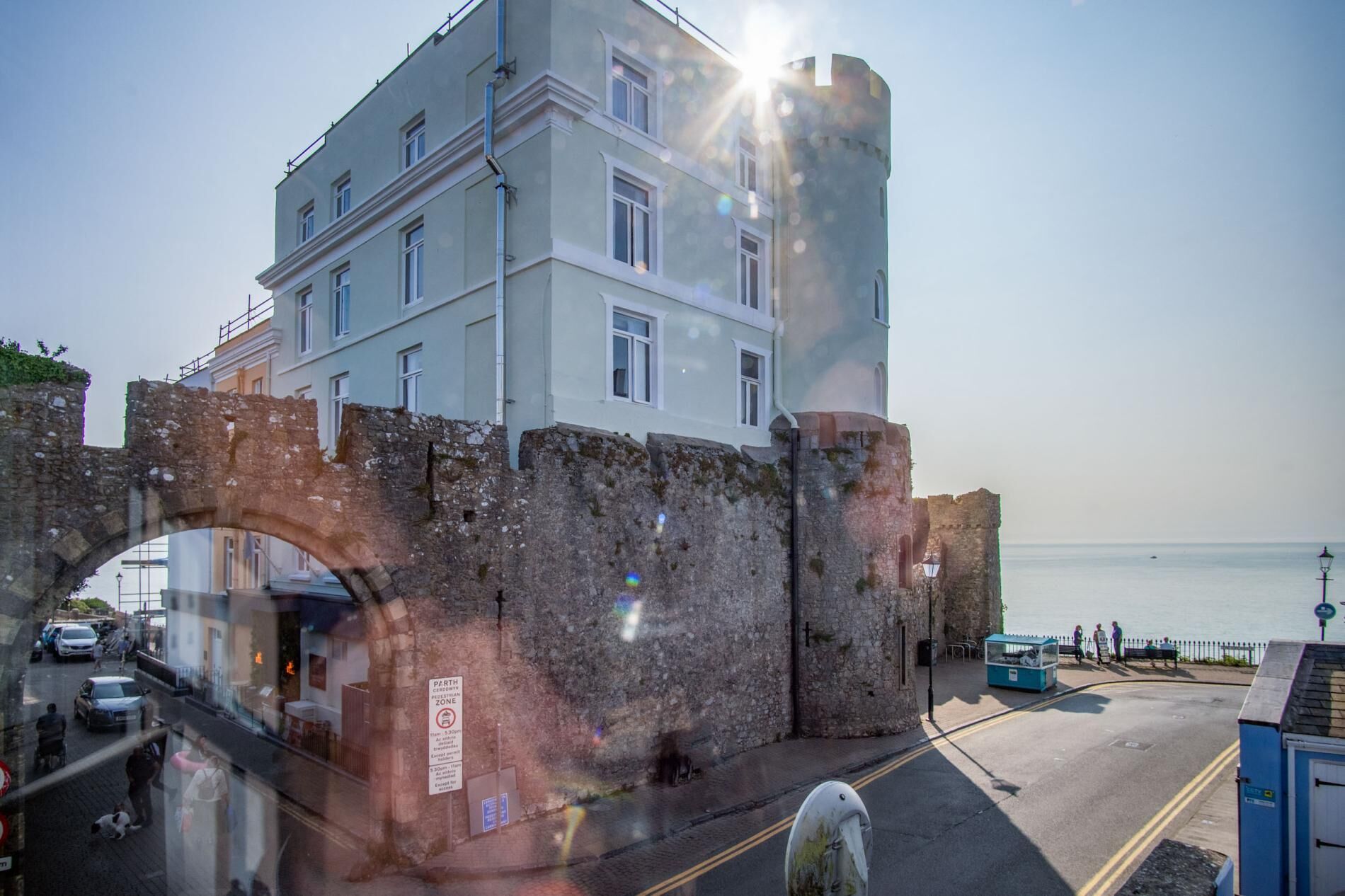 A historic building with a stone wall and a modern upper structure.