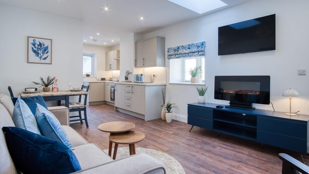 Una sala de estar moderna con un sofá, una mesa de centro y un mueble para la televisión.