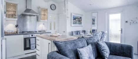 A modern kitchen with white cabinetry, a built-in oven, and a stainless steel range hood.