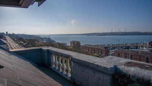 A waterfront view from a balcony with a clear sky, a distant bridge, and a marina with boats. - The Penthouse - 1 Bedroom Penthouse - Milford Haven (Milford Haven)