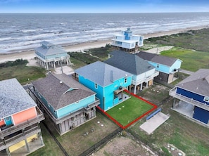 A coastal property with multiple buildings, a fenced yard, and a view of the ocean. - Salty Sunrise 4 Bedroom Home (Port Bolivar)