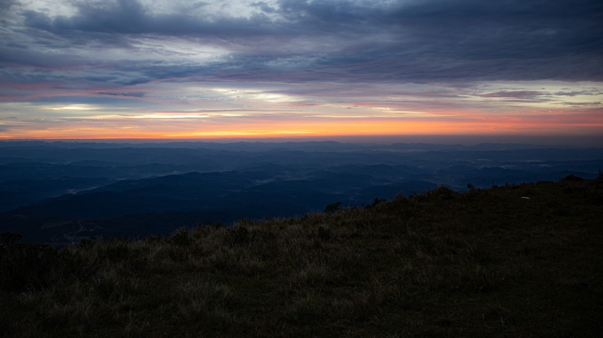 Un paisaje montañoso con un atardecer.