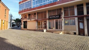 Un edificio con un letrero que dice 'BIOTECAS' en la planta baja, con una escalera que lleva a la entrada.