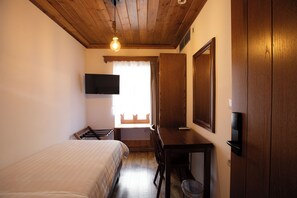 A room with a bed, a desk, a television mounted on the wall, and a window with curtains. - Bizant House Boutique Hotel (Gjirokastër)
