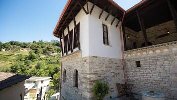 A building with a stone facade, wooden beams, and a sloped roof.