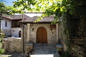 Un edificio de piedra con una puerta de madera, un letrero que indica que es un hotel boutique y una escalera de piedra que conduce a la entrada.