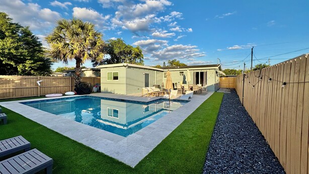 A backyard with a swimming pool, a small house, and a wooden fence. - Private Delray Beach Pool Home Near Atlantic Avenue, Dining & Beach (Delray Beach)