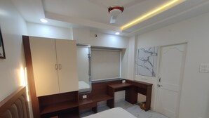 Une chambre à coucher avec un lit, une armoire, un bureau et un miroir.