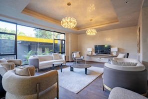 A modern living room with a sofa, chairs, a coffee table, and a TV. - Modern one bed apartment in brilliant Nairobi in secure and calm environment. (Nairobi)