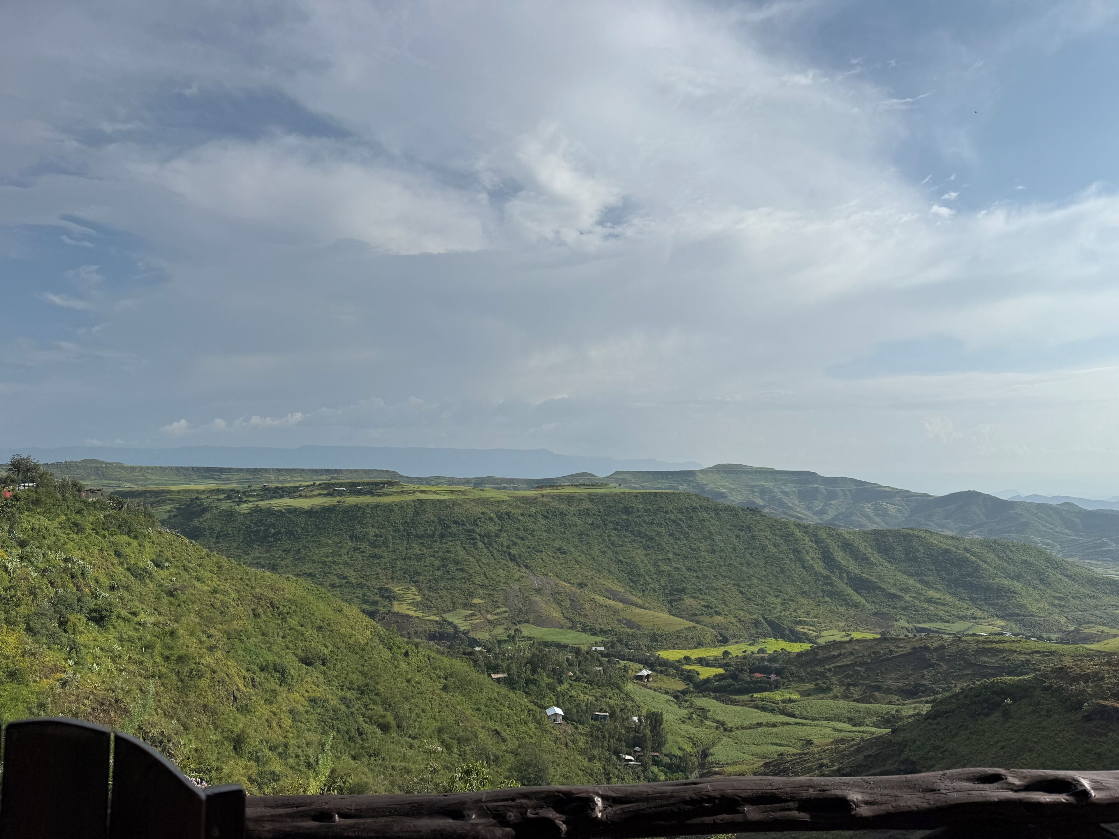 Vista panorámica de un paisaje montañoso con edificios dispersos, probablemente un entorno rural o natural.