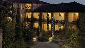 A stone building with multiple balconies, a garden pathway, and string lights. - Hilltop Lodge - Lalibela  (Lalibela)