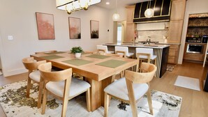 A modern kitchen with wooden cabinets, a central island, and a built-in oven.