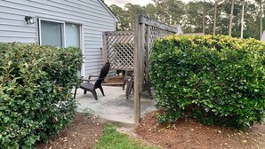 A house with a patio area, a wooden fence, and a chair. - Classy vacay stay at Swansboro (Swansboro)
