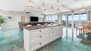A spacious kitchen with a large island, white cabinetry, and pendant lighting. - Tranquility Bayview House-Ocean Front with pool, boat basin and boat ramp (Little Torch Key)