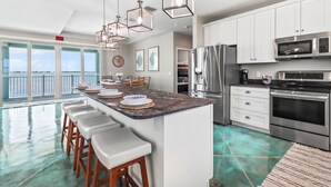 A modern kitchen with a large island, stainless steel appliances, and a view of the ocean. - Tranquility Bayview House-Ocean Front with pool, boat basin and boat ramp (Little Torch Key)