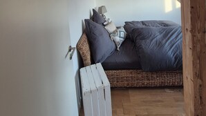 A bedroom with a bed, pillows, a lamp, and a wooden bench.