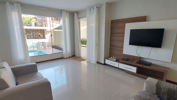 A modern living room with a flat-screen TV, a sofa, and a dining area with a table and chairs. - COPFL0101 - Engenheiro Alves de Souza (Salvador)