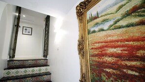 A staircase with patterned steps and a large framed painting of a landscape. - Sasha House-Hotel-Senanikom (Bangkok)