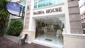 A boutique residence named 'Sasha House' with a glass entrance, a signboard, and a small outdoor seating area with chairs. - Sasha House-Hotel-Senanikom (Bangkok)
