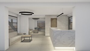 Un espace d’accueil moderne doté d’un comptoir en marbre, de sièges et de luminaires suspendus.
