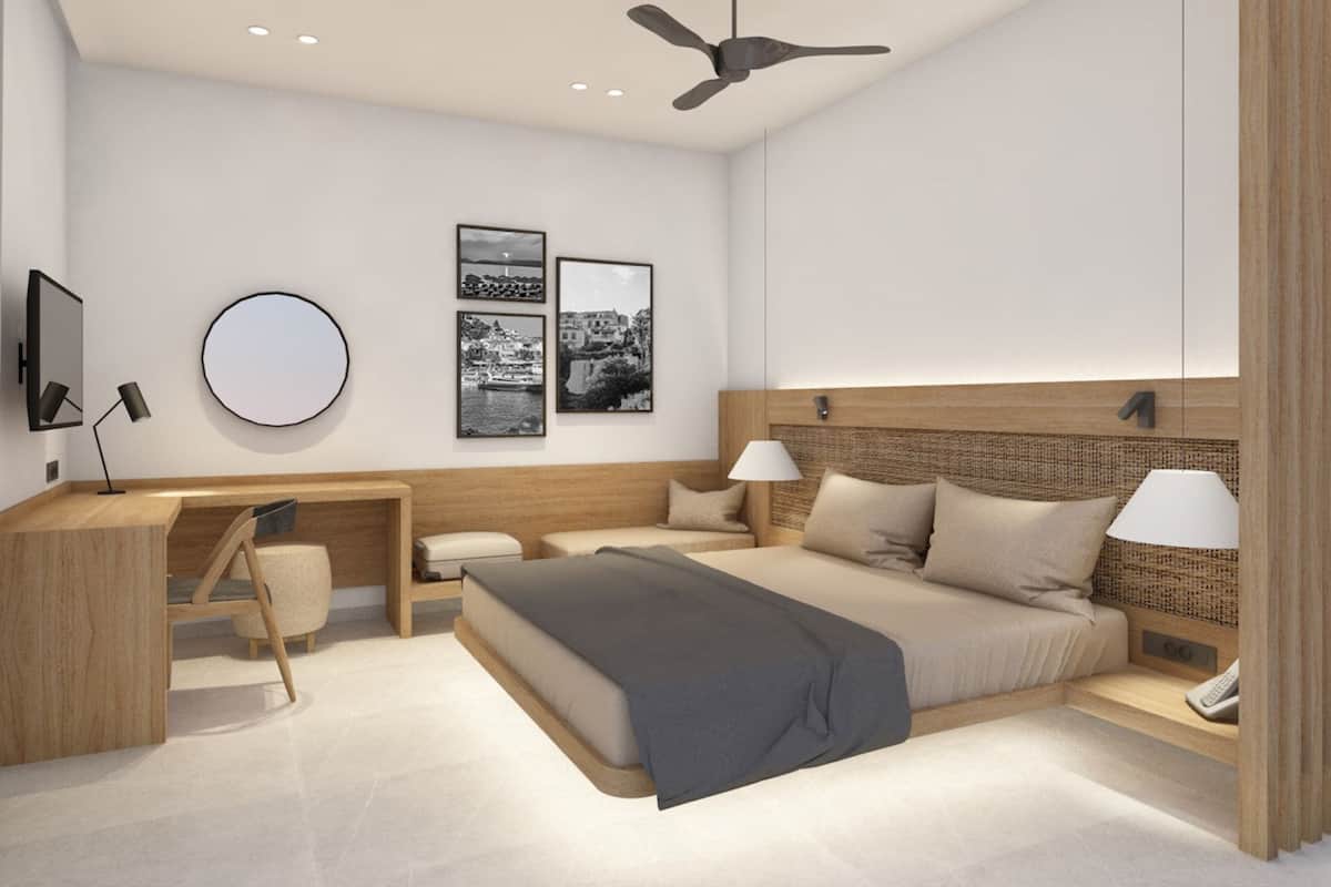 Ein modernes Schlafzimmer mit Bett, Schreibtisch und Sitzgelegenheit, ausgestattet mit Deckenventilator, Wandbildern und einer Nachttischlampe.