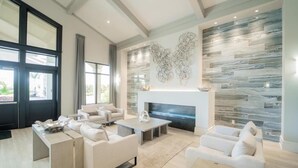 A modern living room with a fireplace, comfortable seating, and a large window.