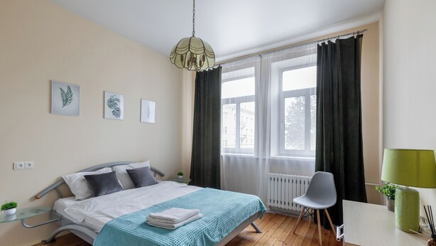 A modern bedroom with a bed, a desk, a chair, and a window with curtains. - Family apartments near Gorky Park (Minsk)