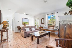 Un salon spacieux avec un canapé, une table basse et une vue sur l’extérieur.