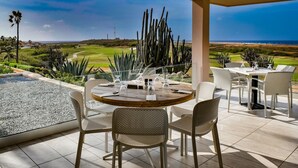An outdoor dining area with a view of a golf course and ocean. - Tierra del Sol home w/ private pool and BBQ! (Noord)