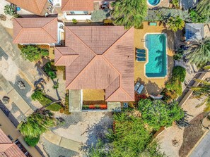 Il s’agit d’une propriété résidentielle dotée d’une piscine, de plusieurs espaces couverts et d’un jardin luxuriant.
