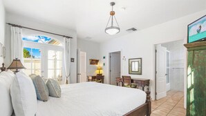 A bedroom with a large bed, a desk, and a view of the outdoors. - Tierra del Sol home w/ private pool and BBQ! (Noord)