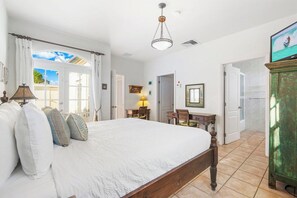 A bedroom with a large bed, a desk, and a view of the outdoors. - Tierra del Sol home w/ private pool and BBQ! (Noord)
