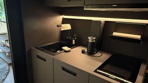 A compact kitchen with a built-in oven, a sink, and a small countertop. - The SeeQuartier - A place to arrive, take a deep breath and enjoy Lake Starnberg (Seeshaupt)