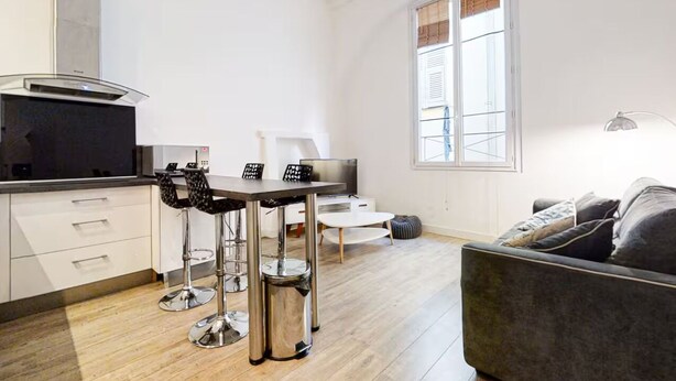 A modern kitchen with a dining area, a sofa, and a large window. - Charm and comfort in the heart of the historic city (Nice)