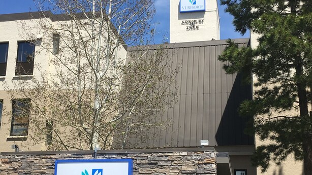 A sign for VI Resorts Kingsbury of Tahoe at 335 Tramway, with a stone wall and a tree in front. - Kingsbury Of Tahoe (Stateline)