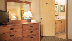 A hotel room with a wooden dresser, a television, a lamp, and a door leading to a bathroom. - Kingsbury Of Tahoe (Stateline)