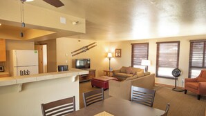 A compact living space with a kitchenette, a dining area, a sofa, and a TV. - Kingsbury Of Tahoe (Stateline)