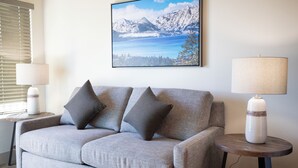 A living room with a grey sofa, two side tables with lamps, and a framed picture of a mountain landscape on the wall. - Tahoe Trail (Stateline)